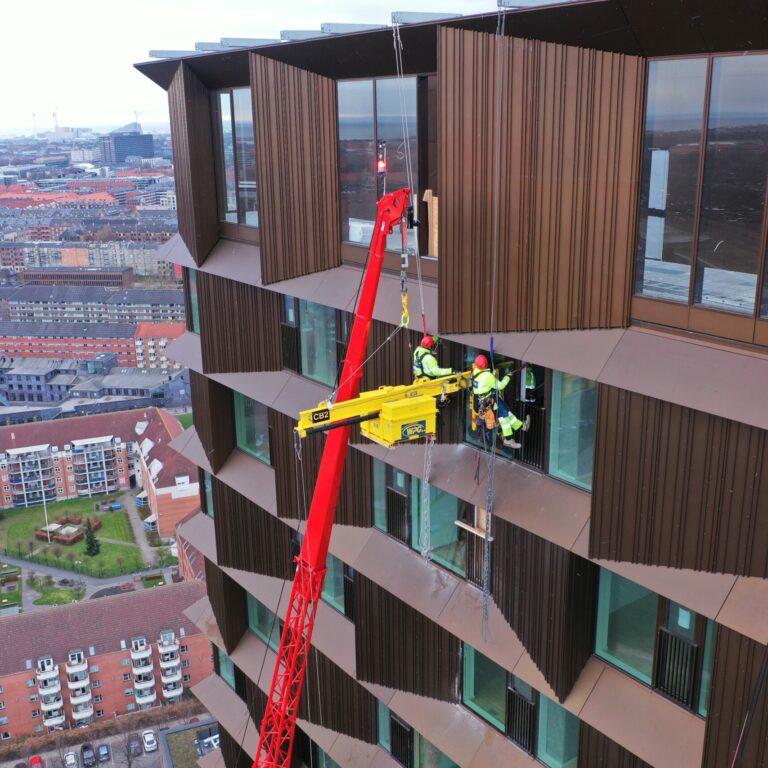 Montage og demontage af vinduer med Rope Access. Her anvendes en mobil kran til løfte vinduet op i højden, hvorefter håndværkere i reb monterer vinduet. Rope Access er fleksibel måde at montere og demontere elementer i højden.